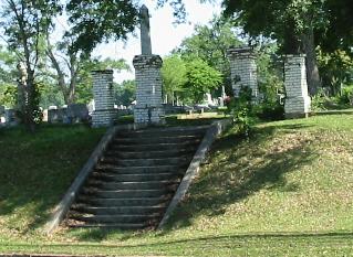 several steps leading to a cemetery next to a hill