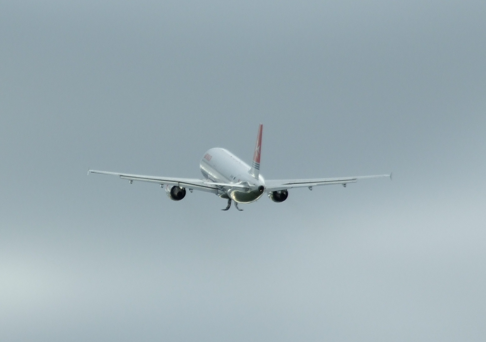 a white and red jet in the sky