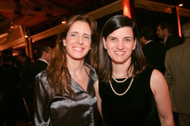 two women smiling for the camera while standing next to each other