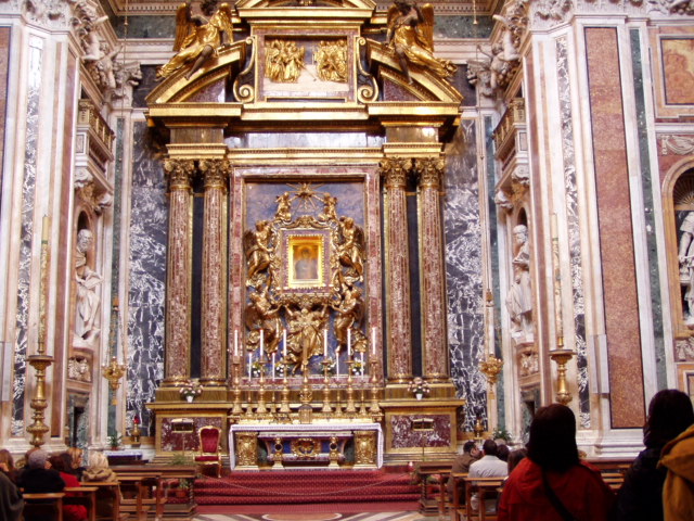 a large gold altar in a church with people around