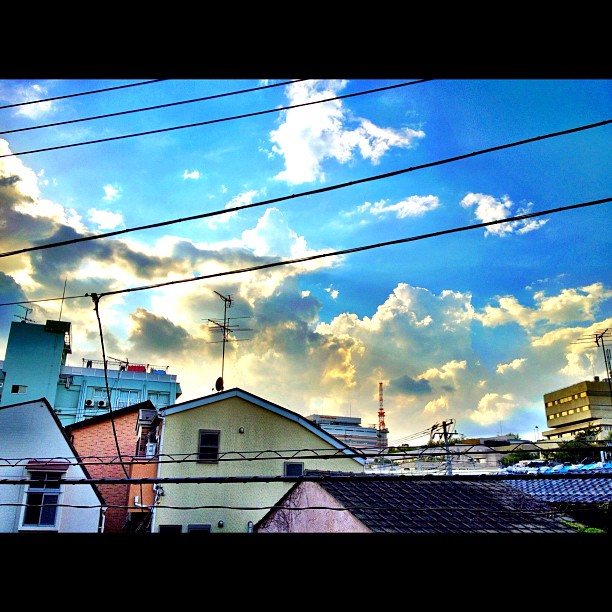 power lines and rooftops near buildings with a cloudy sky