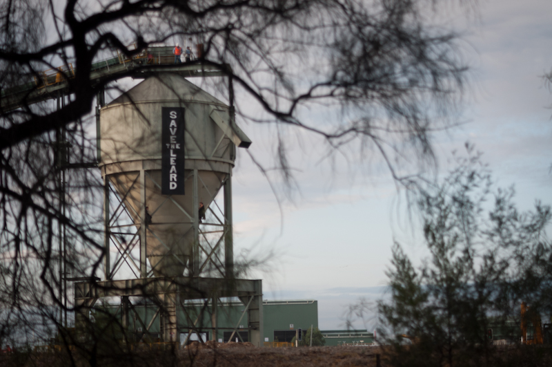 large water tower with trees beside it near the side of a building