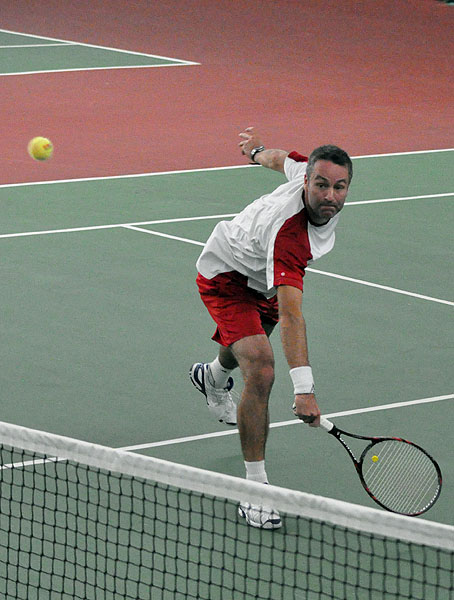 a man on a court with a tennis racket