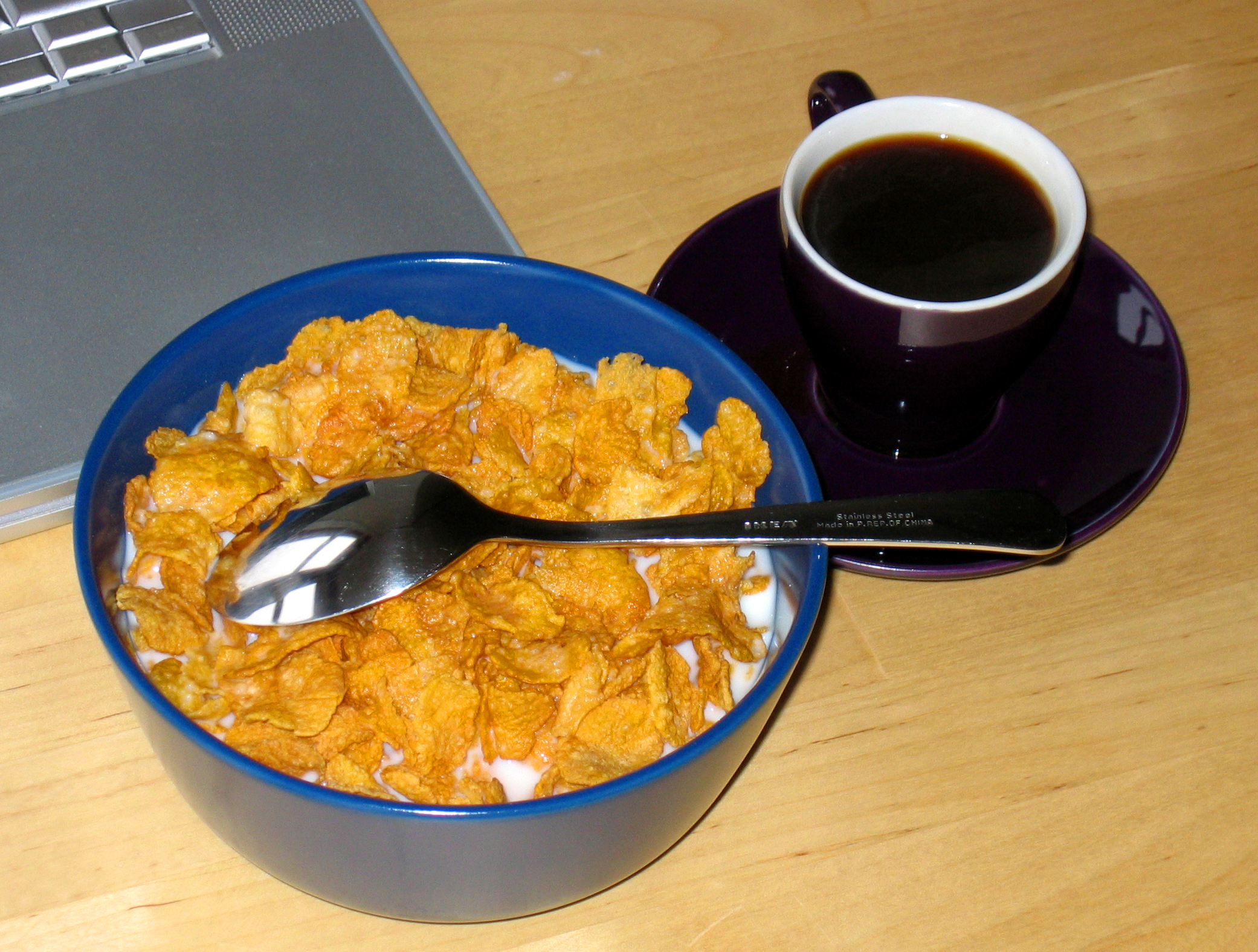 blue bowl filled with cereal, milk and a spoon