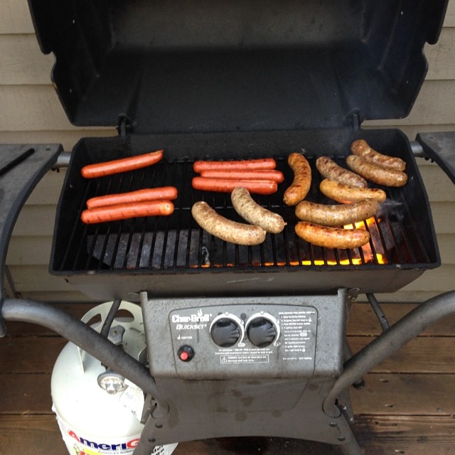 a grill topped with lots of dogs and ketchup