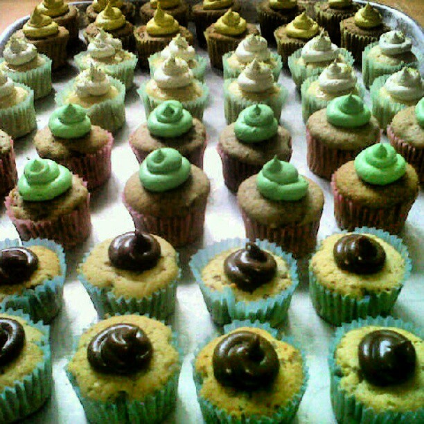 a platter of cup cakes decorated in chocolate and mint colors