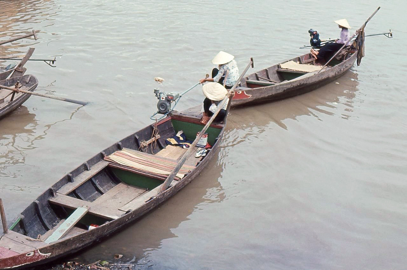 two boats that have people in them sitting in the water