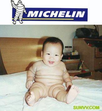 a baby sits on the bed with a michel sign in the background