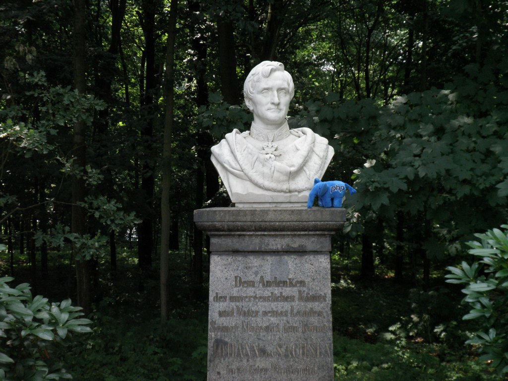a statue in the middle of the forest with blue gloves on