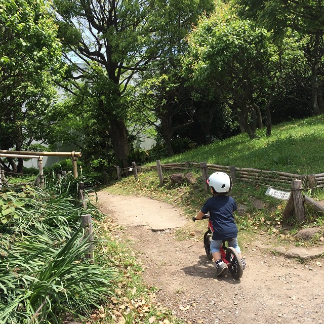 the little boy is riding his bicycle on the trail