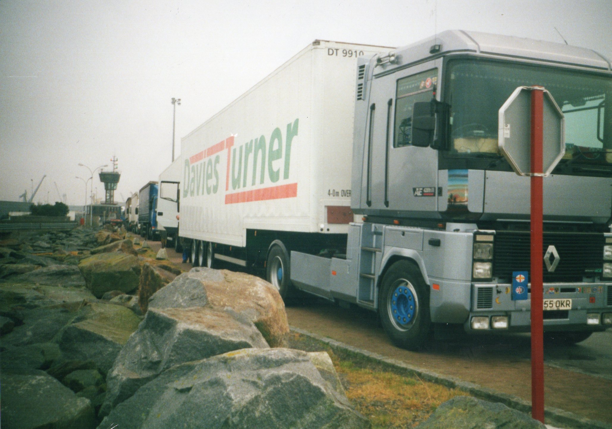 a truck drives down the street next to rocks