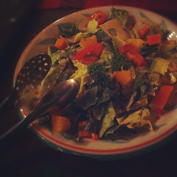 a plate with a large salad with carrots and broccoli