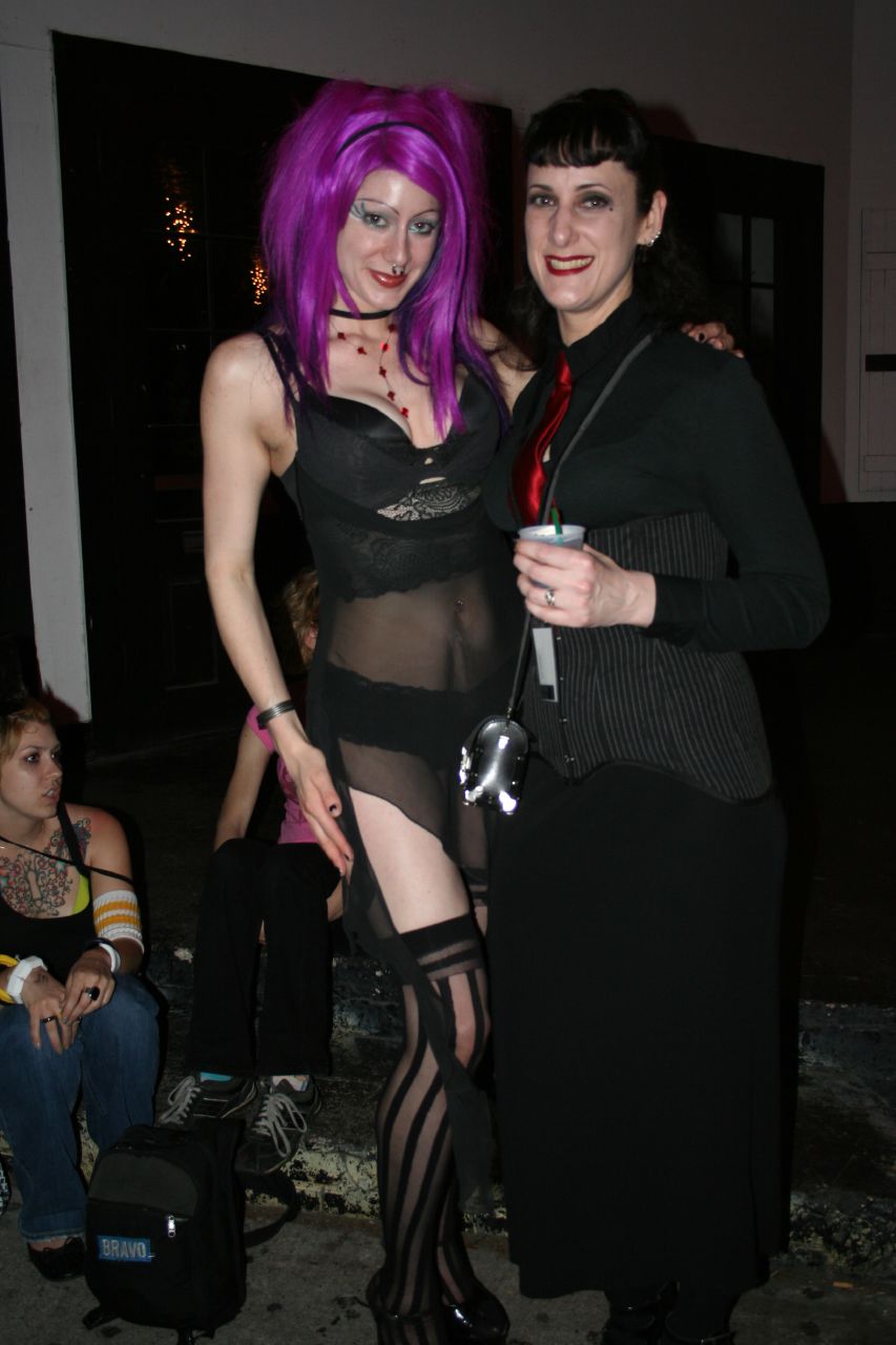 two beautiful young women dressed up in black posing for a picture