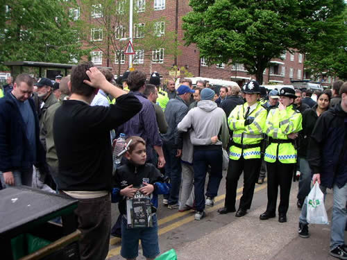 the crowd is gathered in front of the police car