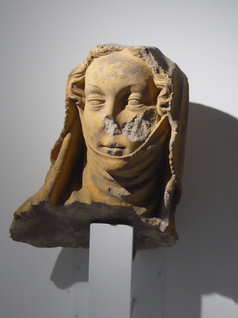 a sculpture of a woman's head on display against a wall