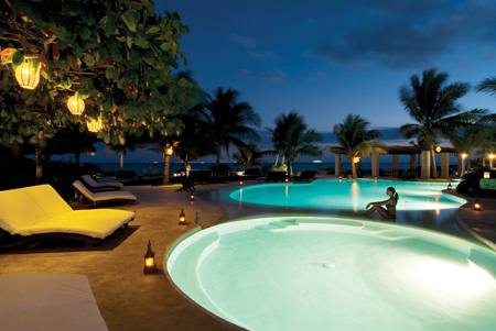 a el pool with lighted lounge chairs around the pool