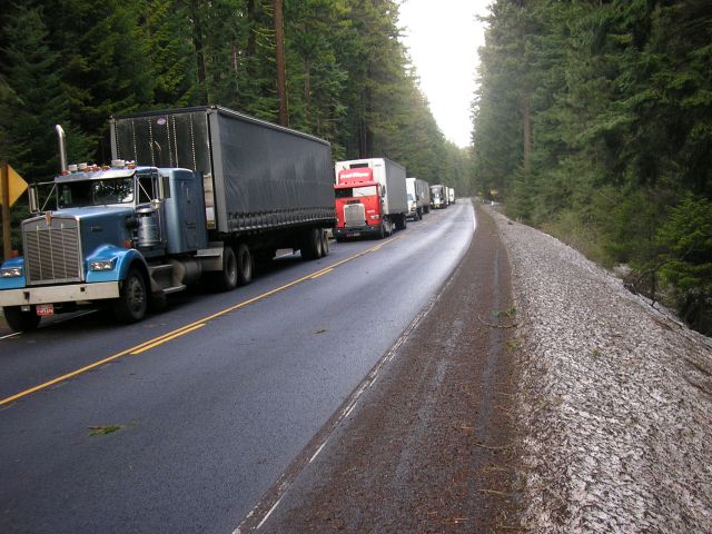 semis are parked in the middle of a quiet road