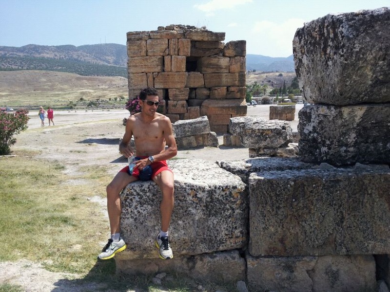 a man with  on sitting on top of some big rocks