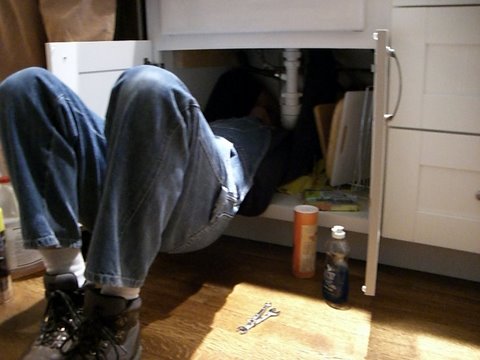 a person in a room under a cabinet with their feet up