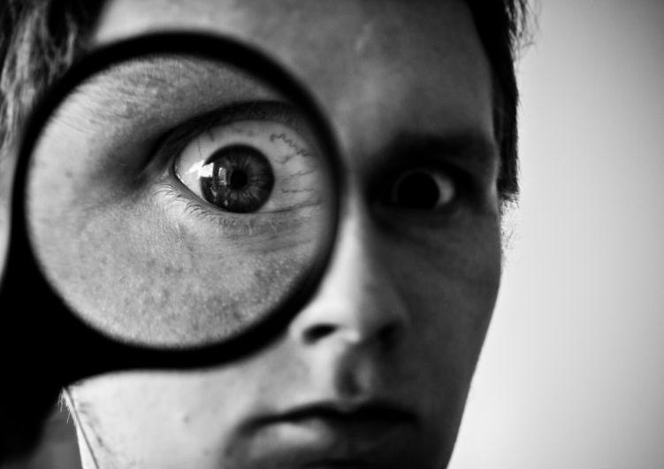 a man looks through a magnifying glass