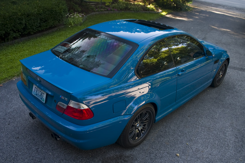 the blue car is parked on the sidewalk