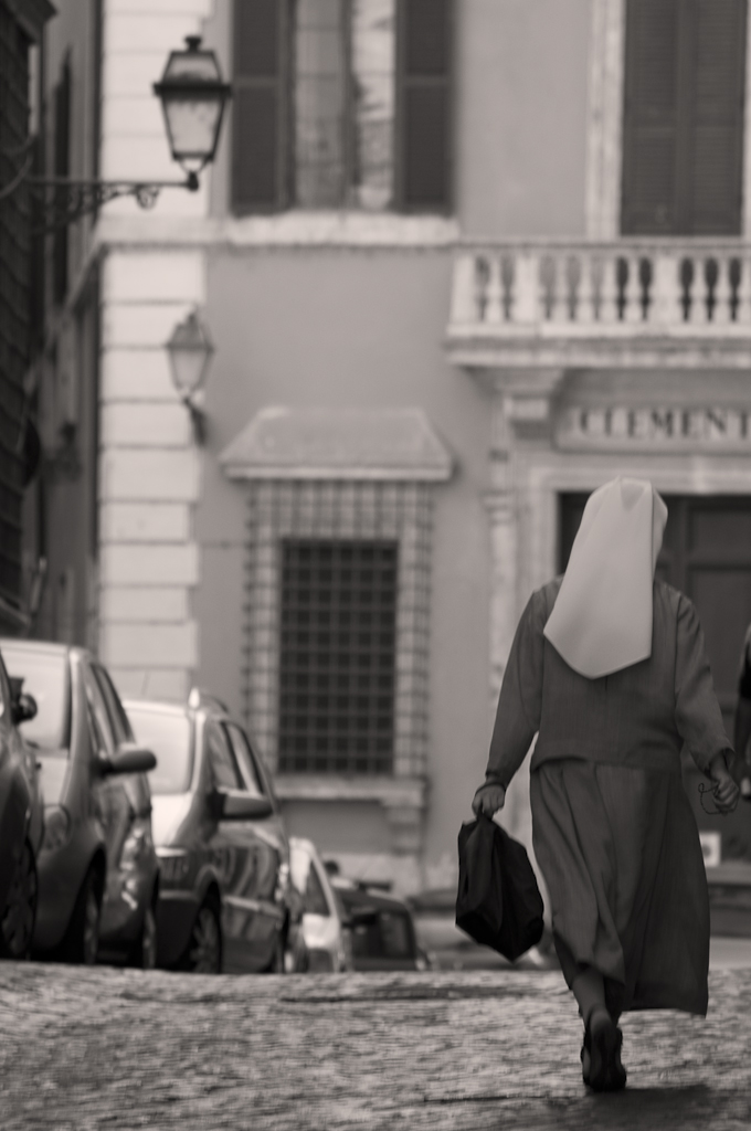 a woman walking down the street next to parked cars