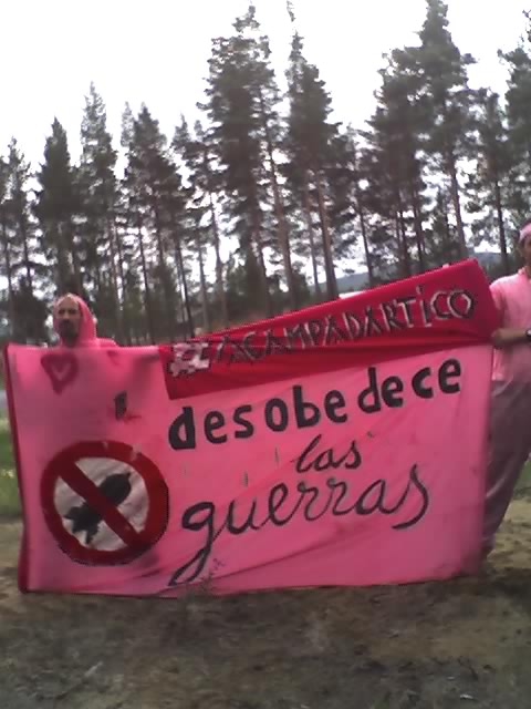 two people holding up pink sign with an image of a no swimming zone and a red banner