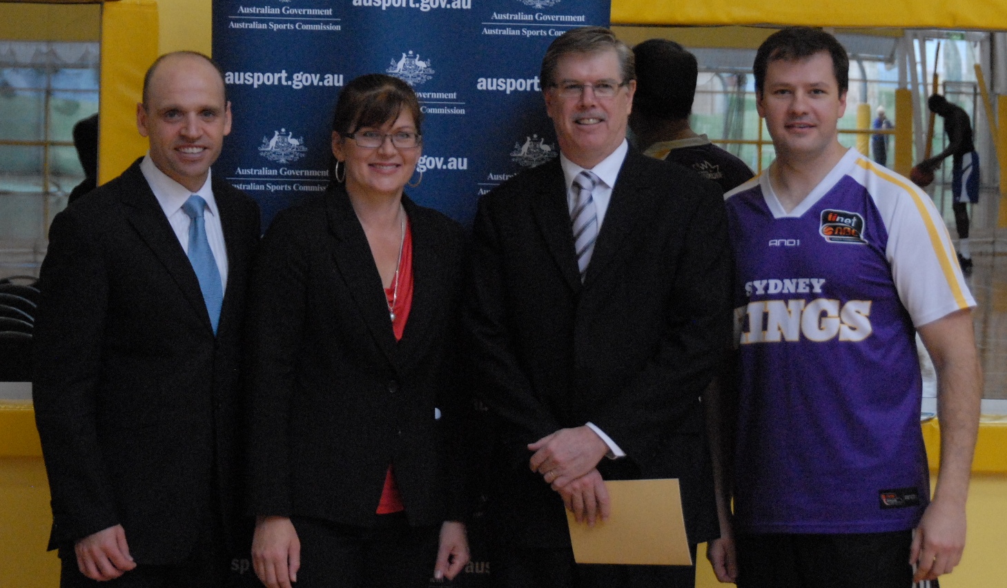 there are three men and two women posing for the camera