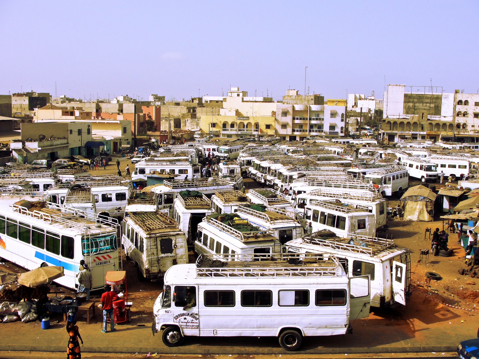 a large parking lot with cars and buses