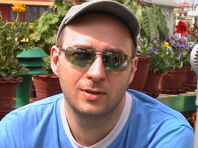 a man is holding a plant and wearing sunglasses