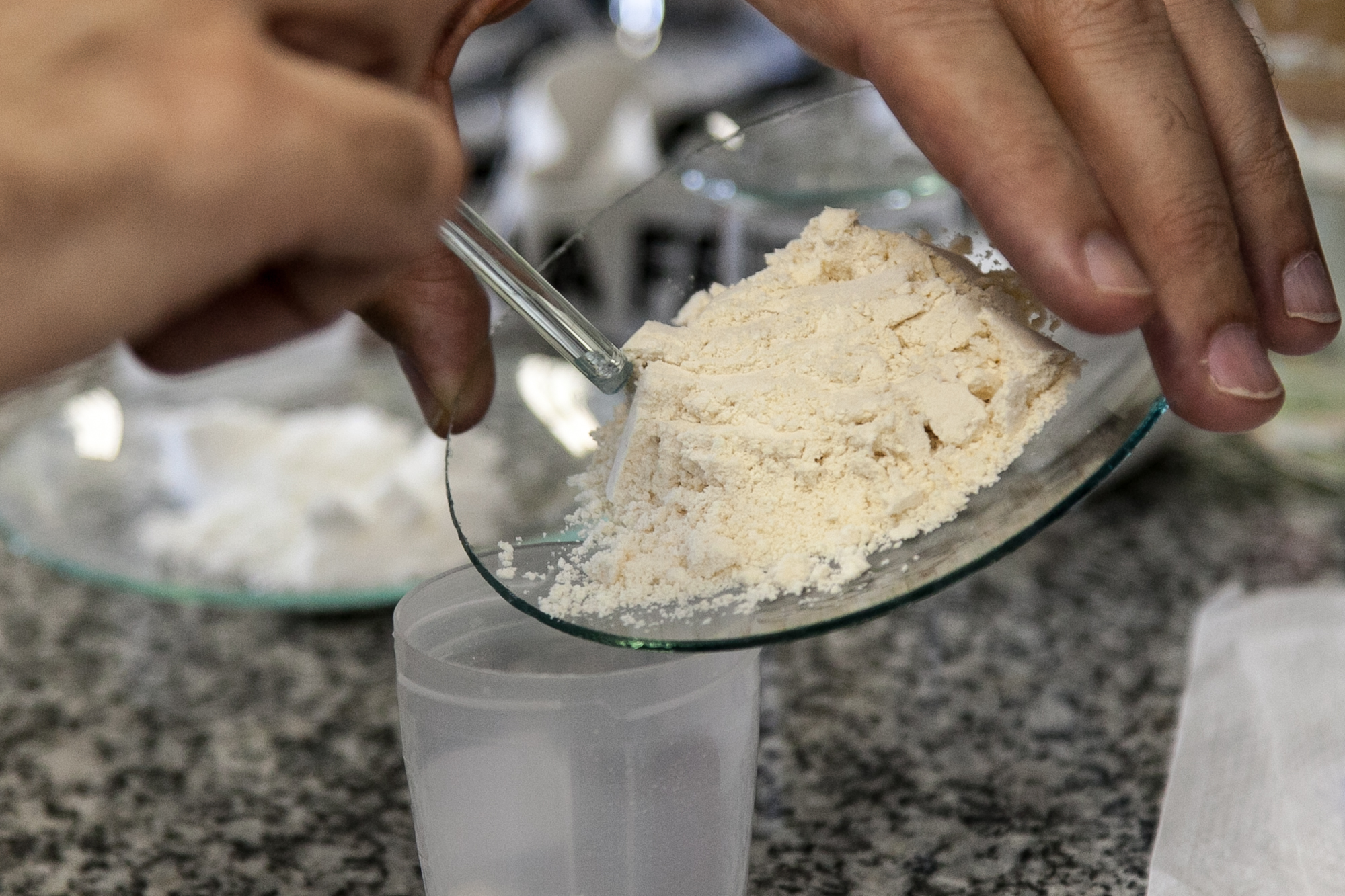 a person scooping sugar into a bowl