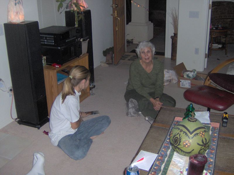 two ladies sitting in a living room, one with the carpet covered