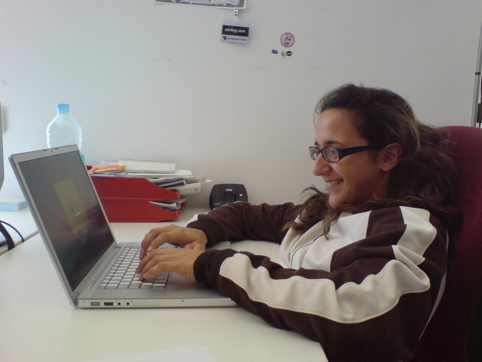 a girl with glasses working on her laptop computer