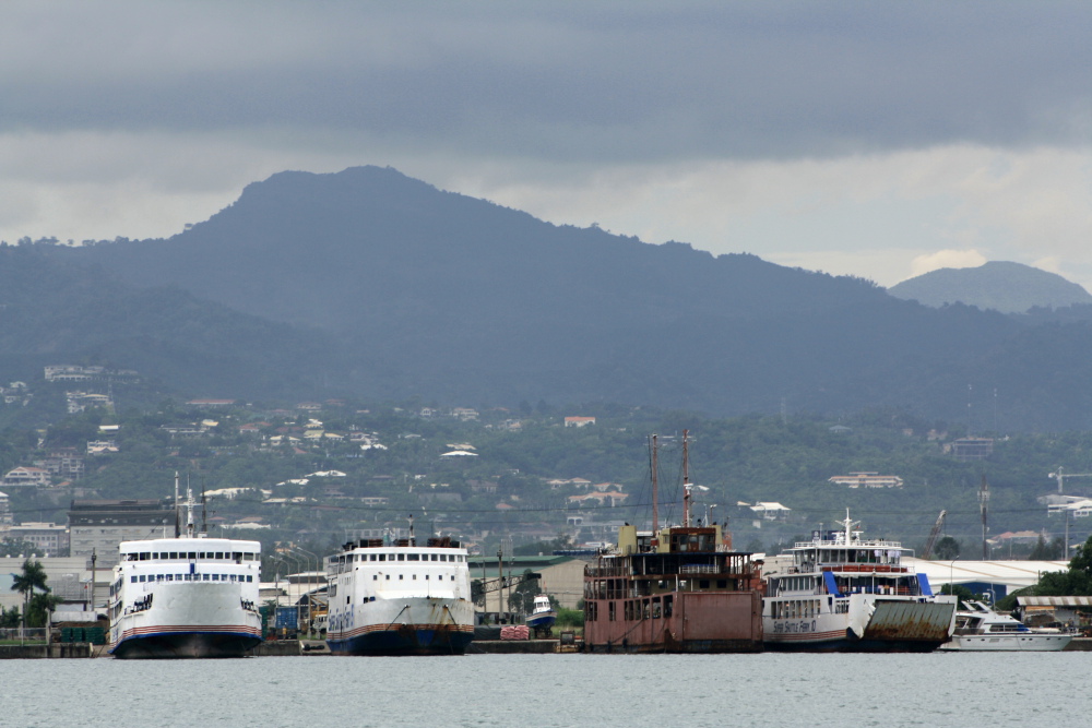 two boats are parked at a dock by the mountains