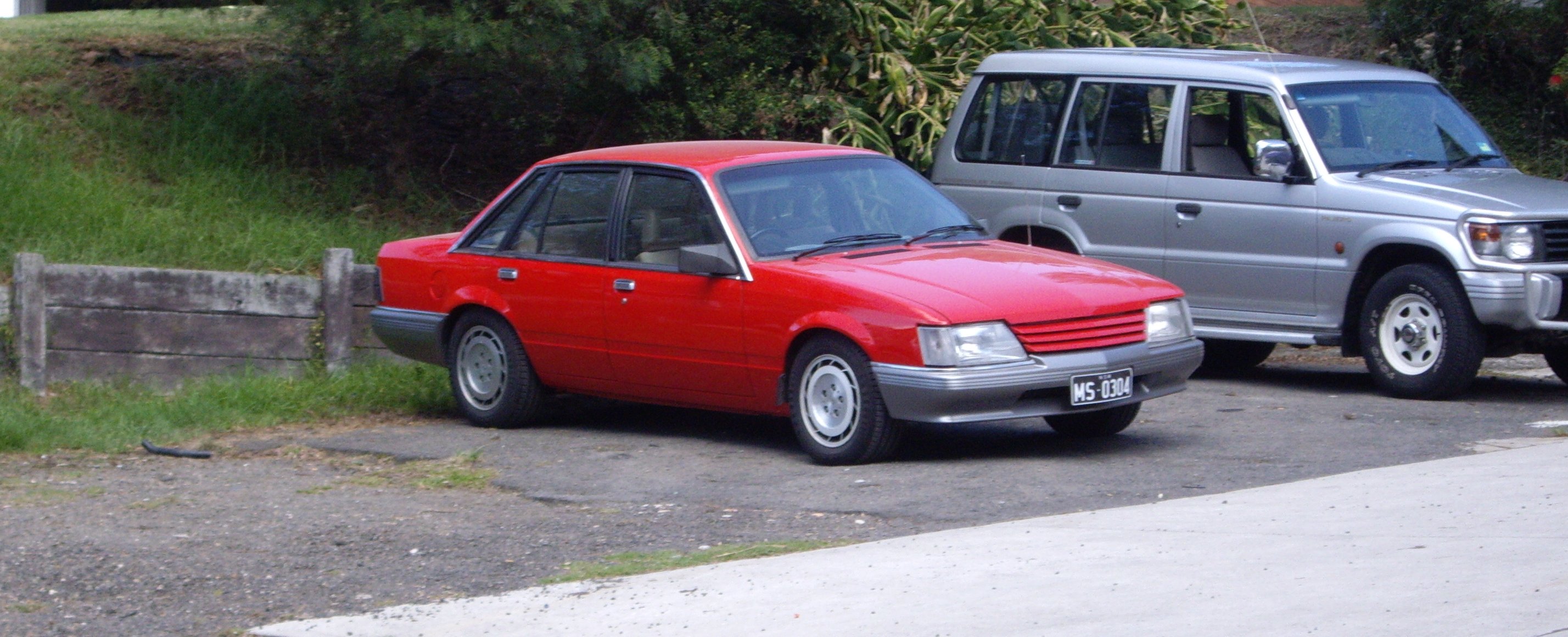 a car parked on the side of a street next to another vehicle