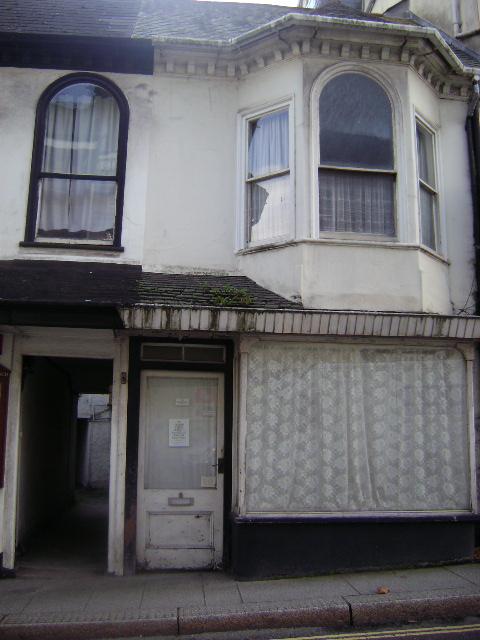 a boarded up building on the corner of an intersection