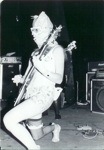 an image of a woman wearing lingerie on stage playing a guitar