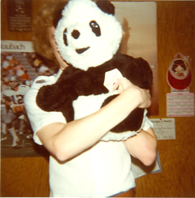 a woman holding a stuffed panda bear at a home