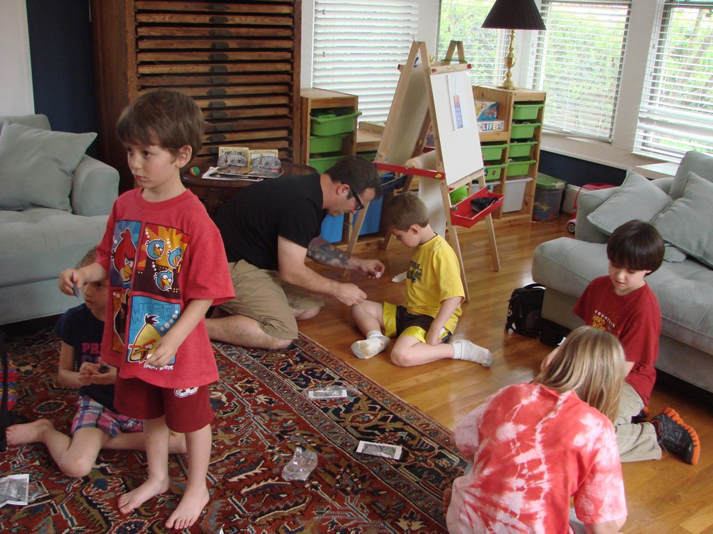 three adults and two children sitting in a room with a rug