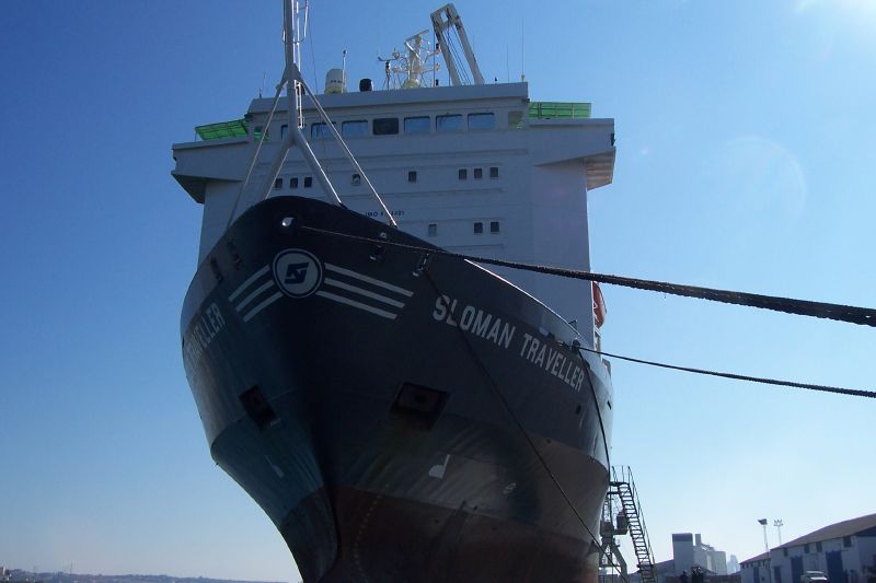 a black and white ship is docked at a pier