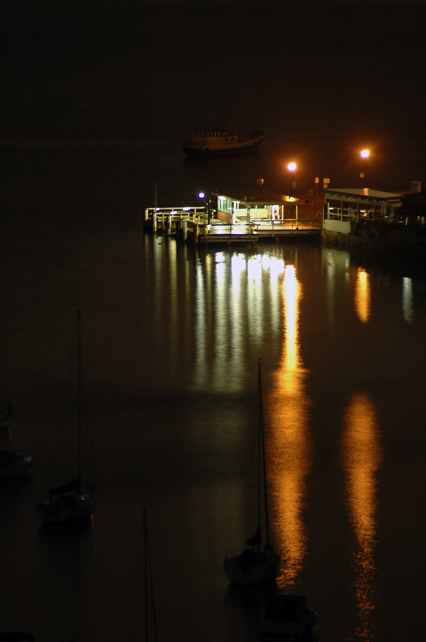 a large boat floating down a river under night lights