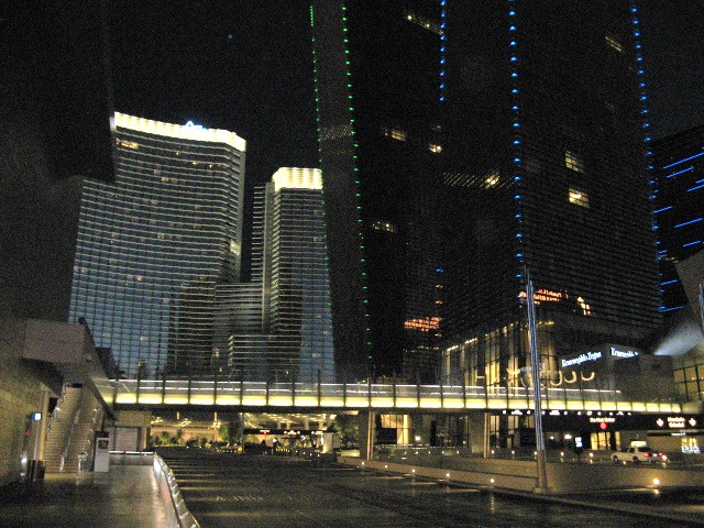 a city at night with illuminated buildings and people walking