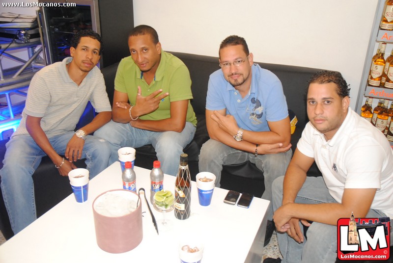 three men sitting next to each other on a couch