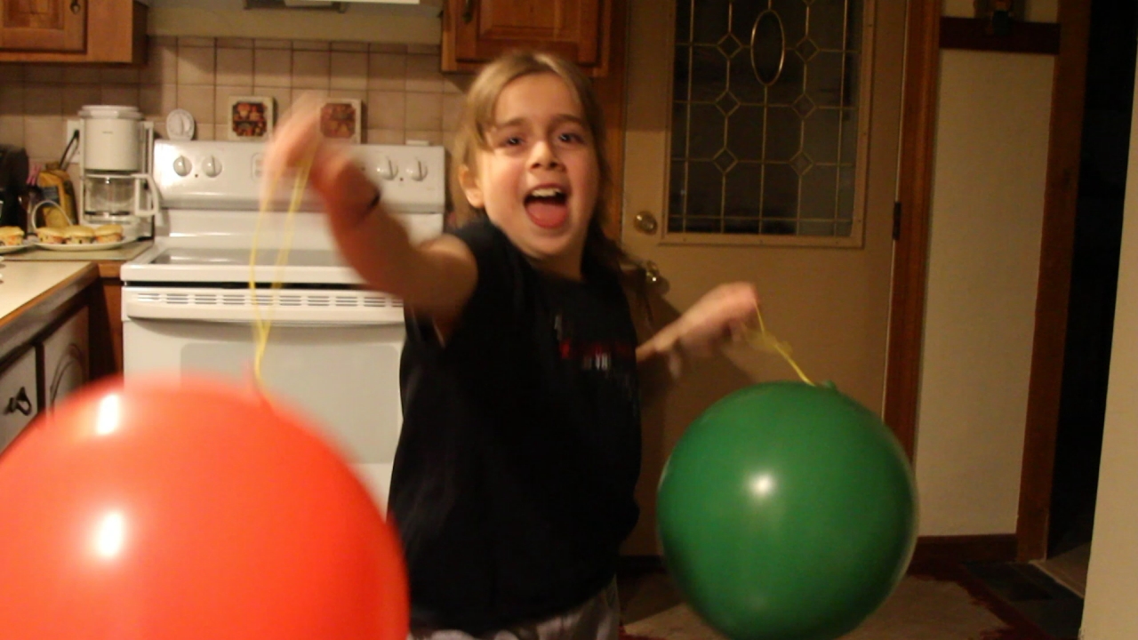 a child holding two large balloons in their hands