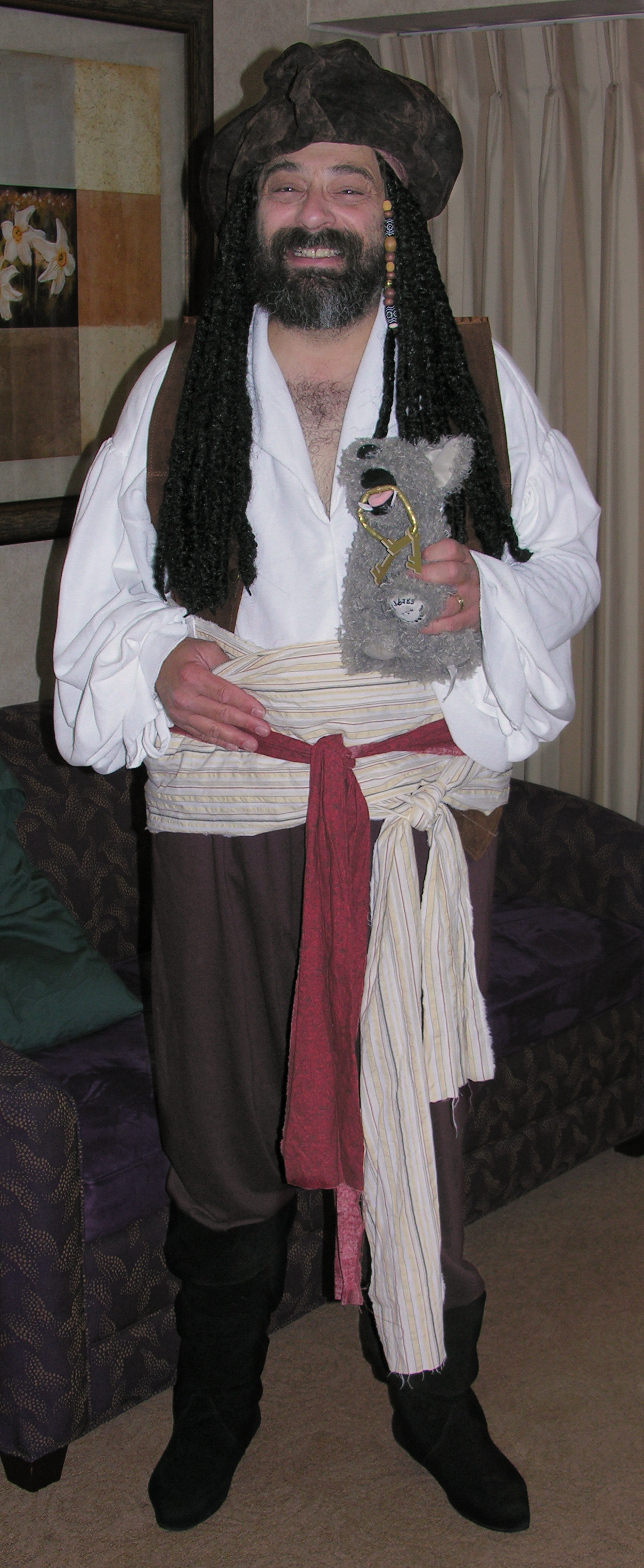 a man dressed in pirate clothing, holding a stuffed animal