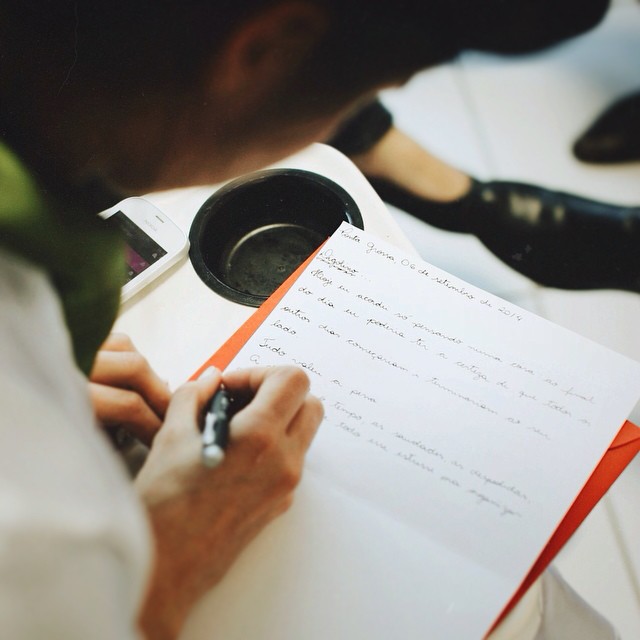 a person writing on a notepad while holding a pen