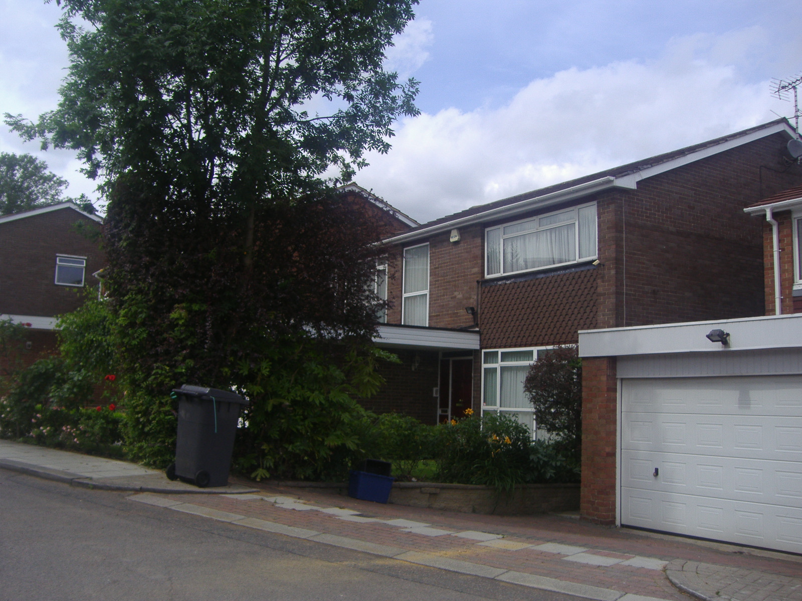 the house with all the landscaping on one side of the street