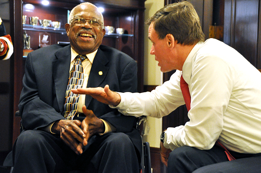 two men who are sitting down with their hands on each other