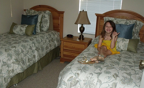 the girl smiles in her room next to the two beds