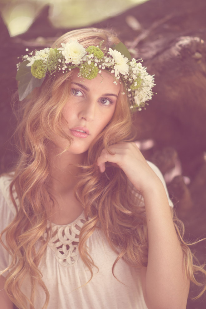 a girl with flowers on her head and a flower crown around her head